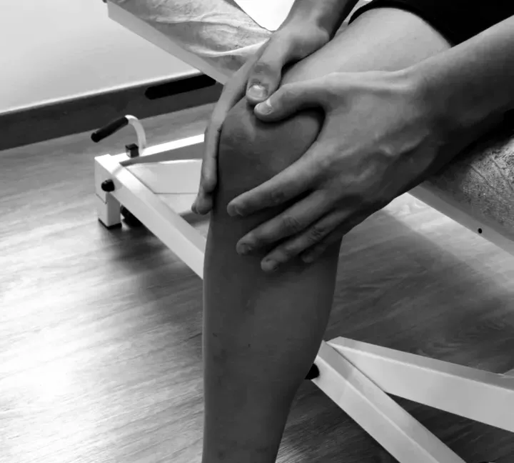 Las manos del fisioterapeuta en la rodilla